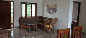 a living room with a couch and chairs at Waterfront Family Homestay ( Jameela Manzil). in Murinjupuzha
