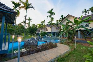 a resort with a swimming pool and palm trees at Feel Free Retreat in Kalpetta