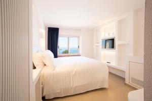 a white bedroom with a large bed and a window at Pagoda Lifestyle Hotel in Ischia