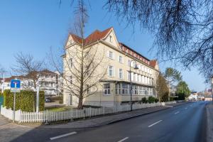 un grand bâtiment blanc sur le côté d'une rue dans l'établissement Haus Godewind Ferienwohnung 14 mit Strandkorb, à Binz