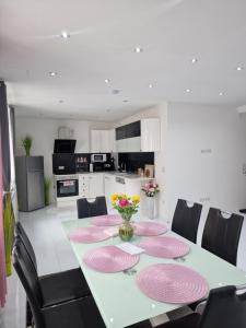 Deea Apartment في Schottwien: غرفة طعام مع طاولة مع أطباق وردية وكراسي