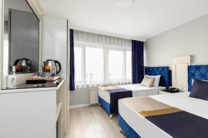 a hotel room with two beds and a kitchen at Sirkeci Grand Family Hotel & SPA in Istanbul