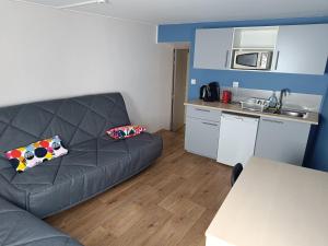 a living room with a couch and a kitchen at La Mansio de Bons in Les Deux Alpes