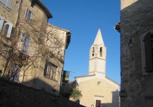 a tall white church with a steeple on a street at LAVOUTE in Durfort-et-Saint-Martin-de-Sossenac