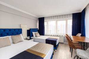 Sirkeci Grand Family Hotel & SPA في إسطنبول: غرفة فندقية بسريرين وطاولة