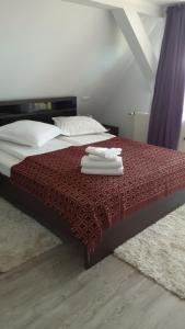 a bed with two towels on top of it at Pensiunea IULIA in Rod
