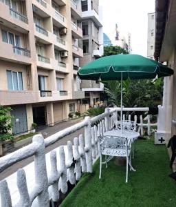 einen Tisch und einen Regenschirm auf dem Balkon in der Unterkunft THE WISH RESIDENCE BEACH SIDE KOLUPITIYA Colombo 3 in Colombo