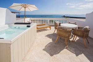 a patio with a hot tub and a table and chairs at Pagoda Lifestyle Hotel in Ischia