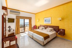 a hotel room with a bed and a balcony at Hotel Casabela in Ferragudo