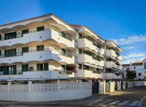 een hoog wit gebouw met balkons in een straat bij AT044 Els Porxos in Torredembarra