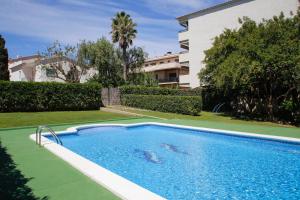 een zwembad in een tuin naast een gebouw bij AT044 Els Porxos in Torredembarra