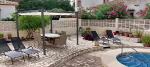 a patio with chairs and a table and a pool at Villa al Mar, Els Poblets, Top Lage und Ausstattung, Pool, WIFI, eigener überdachter Parkplatz, Photovoltaik-Anlage nah am Strand 500m in Miraflor