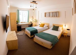 Cette chambre comprend deux lits et un bureau. dans l'établissement Hotel Rehavital, à Jablonec nad Nisou
