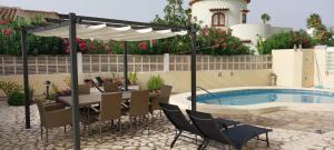 a patio with a table and chairs next to a pool at Villa al Mar, Els Poblets, Top Lage und Ausstattung, Pool, WIFI, eigener überdachter Parkplatz, Photovoltaik-Anlage nah am Strand 500m in Miraflor