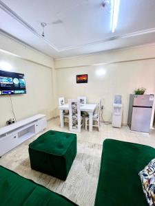 a living room with a table and a green ottoman at Luxe suite (1bedroom) in Nambale