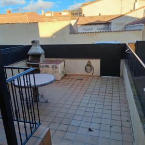 a patio with a table and a grill on a balcony at Río Adaja in El Fresno +4 photos