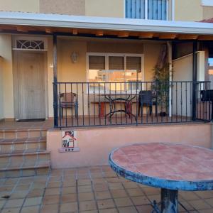 Casa con balcón con mesa y sillas. en Río Adaja, en El Fresno