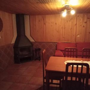 a living room with a fireplace and a table and a couch at Río Adaja in El Fresno