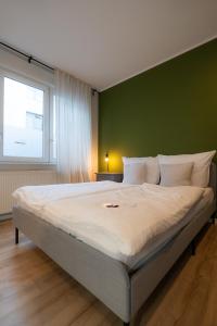 sypialnia z dużym łóżkiem i zieloną ścianą w obiekcie Im Herzen der Stadt - EG Wohnung w mieście Paderborn