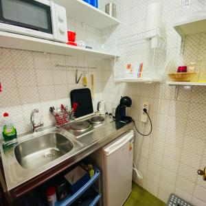 uma pequena cozinha com um lavatório e um micro-ondas em Elegante Loft en Chueca em Madri