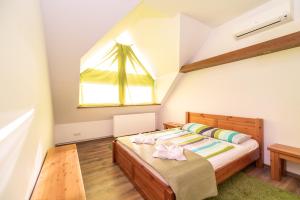 Dormitorio pequeño con cama y ventana en Juhar Apartmanház, en Balatongyörök