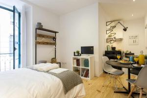 a bedroom with a bed and a table with chairs at Urban Design Estudio no Centro com Ar Condicionado in Lisbon
