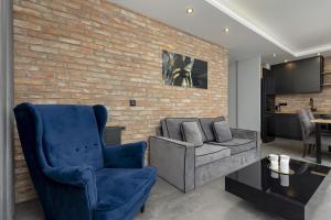 a living room with a brick wall at Milionowa Loft Apartment with Parking in Łódź by Noclegi Renters in Łódź +25 photos