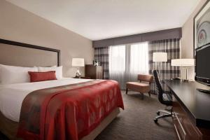 a hotel room with a bed and a desk at Ramada Plaza by Wyndham Regina Downtown in Regina