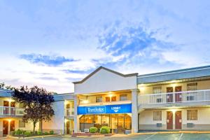 un grande edificio bianco con un cartello blu sopra di Travelodge by Wyndham Silver Spring a Silver Spring