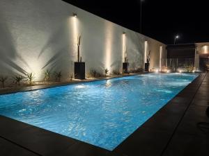 a large swimming pool with blue water at night at منتجع LA in Al Wudayy