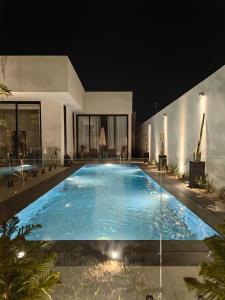 a large swimming pool in a house at night at منتجع LA in Al Wudayy
