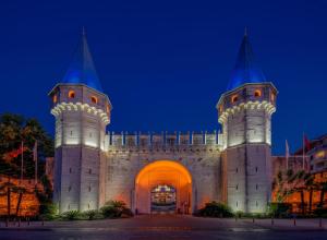a building with two towers at night at Swandor Hotels & Resorts - Topkapi Palace in Lara