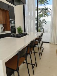 a kitchen with a long counter with a row of chairs at منتجع LA in Al Wudayy