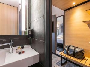 uma casa de banho com um lavatório branco e um espelho. em ibis Nancy Centre Stanislas em Nancy