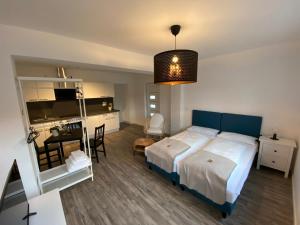 a bedroom with a bed and a desk and a kitchen at Hotel Apartments Restaurant CALA LUNA in Marburg an der Lahn