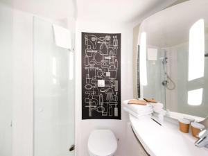 a bathroom with a black and white picture on the wall at ibis Bordeaux Centre Bastide in Bordeaux