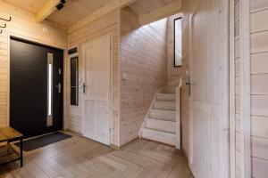 eine Treppe in einem Holzhaus mit einer Tür in der Unterkunft Solo na wyspie, blisko morza Sobieszewo in Danzig