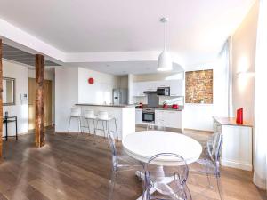 a kitchen and dining room with a white table and chairs at Novotel Toulouse Centre Wilson in Toulouse