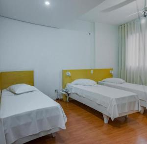 a hospital room with two beds and a window at Hotel San Gabriel in Sao Paulo