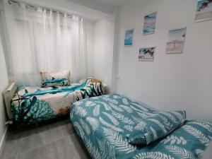 sypialnia z 2 łóżkami i oknem w obiekcie Fantástico Piso Turquesa w mieście Valladolid