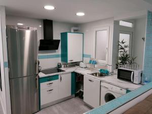 a kitchen with a refrigerator and a microwave at Fantástico Piso Turquesa in Valladolid +27 photos