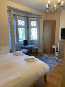 1 dormitorio con 1 cama blanca grande y escritorio en Parkview Guesthouse en Cambridge