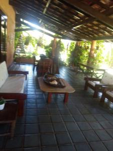 Habitación con mesa y bancos en el patio. en Mansao Santa Rita, en Cumbuco
