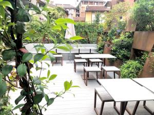 une rangée de tables et de bancs dans un jardin dans l'établissement Best Western Plus Park Hotel Pordenone, à Pordenone