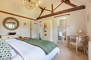 a bedroom with a bed and a desk and a mirror at Perry Cottage in Halford