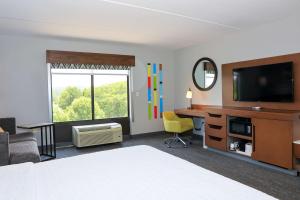een hotelkamer met een bed, een bureau en een televisie bij Hampton Inn Atlanta-Canton in Canton