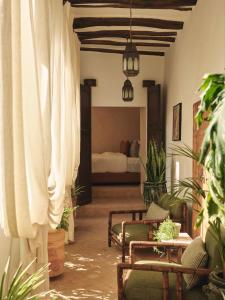 IZZA Marrakech في مراكش: غرفة معيشة مع ستائر بيضاء وسرير