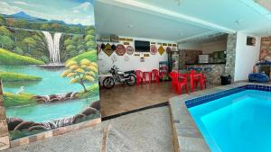 uma casa com piscina e uma pintura de uma cascata em Pousada Caminho das Cachoeiras Pirenopolis em Pirenópolis