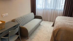 um quarto de hotel com um sofá e uma cama em Penzión Holub em Banská Bystrica