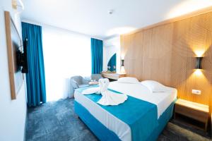 Habitación de hotel con cama azul y blanca en Hotel Parc en Mamaia